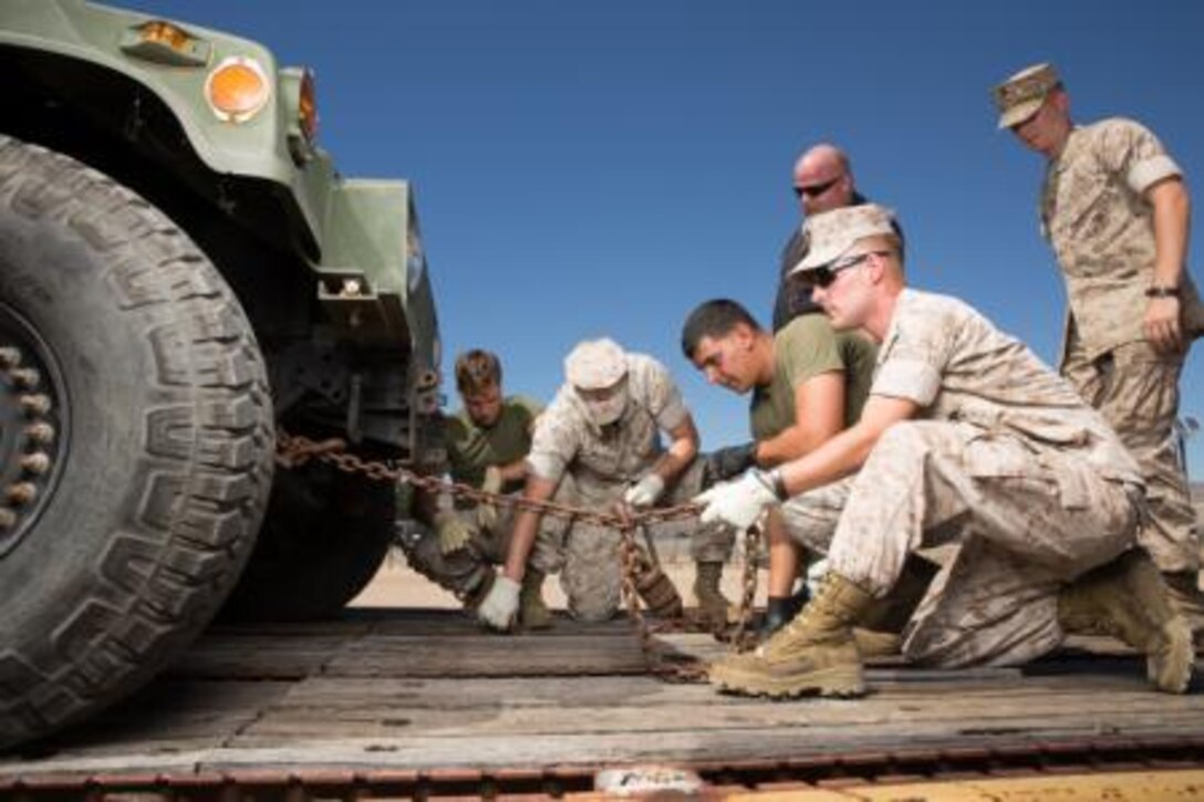 Marines from Combat Logistics Battalion-15 practice securing a Humvee to a rail car while aboard Marine Corps Logistics Base Barstow, Calif. on Aug 15. The Marines learned how to load, tie down, and prepare vehicles for transportation via rail in order to expand their logistical skill set.