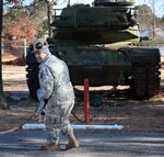 Sgt. 1st Class James Walker of the New Jersey National Guard runs a cable to an M-60 tank before trying to move the tank between Veterans of Foreign Wars posts in Brick on Tuesday.