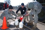 From left to right, Spc. Anthony Brewer with the 77th Engineer Detachment in Jasper, Ala., Jason Thomas with the Bon Secour Fire Department in Baldwin County, Ala., and Pfc. Kevin Offutt with the 186th Engineer Company in Dothan, Ala., help fill jugs with non-potable water for the citizens of Thomasville, Ala. Due to subzero temperatures, many residents in Thomasville and surrounding towns have been without water for almost a week. Brewer and Offutt, along with two other Alabama guardsmen, will remain in Thomasville for as long as there is a need.