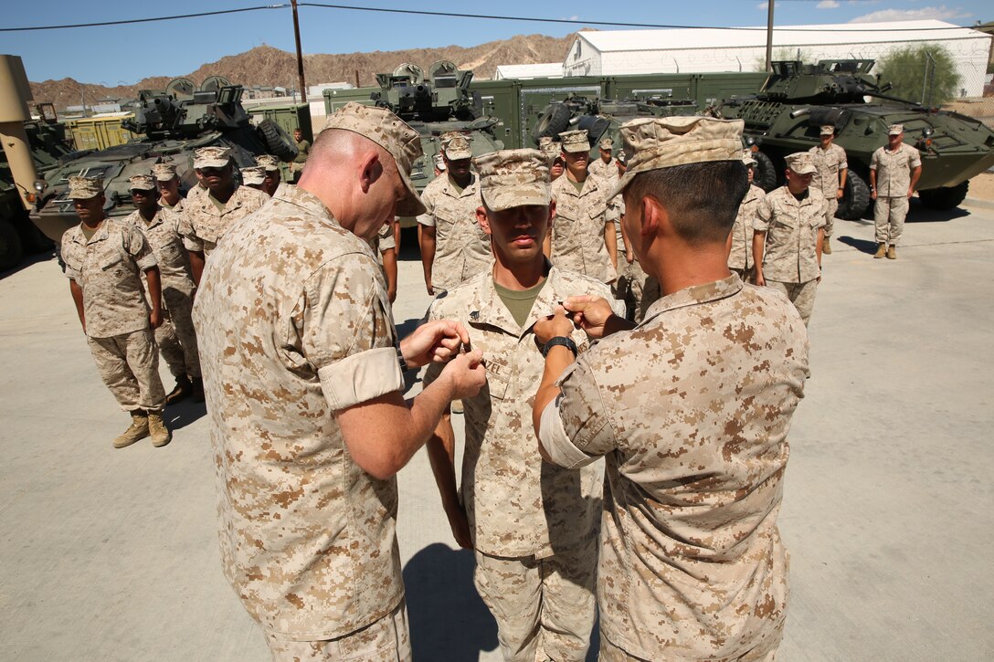 Master Sgt. Michael W. Wilson, communications chief, 3rd Light Armored Reconnaissance Battalion, and Capt. Kelvin Chew, communications officer, S-6, 3rd LAR, pin Sgt. Arthur E. Krenzel III, field radio operator, 3rd LAR, during his meritorious promotion ceremony at the Communications Building of 3rd LAR, Aug. 15, 2014.


