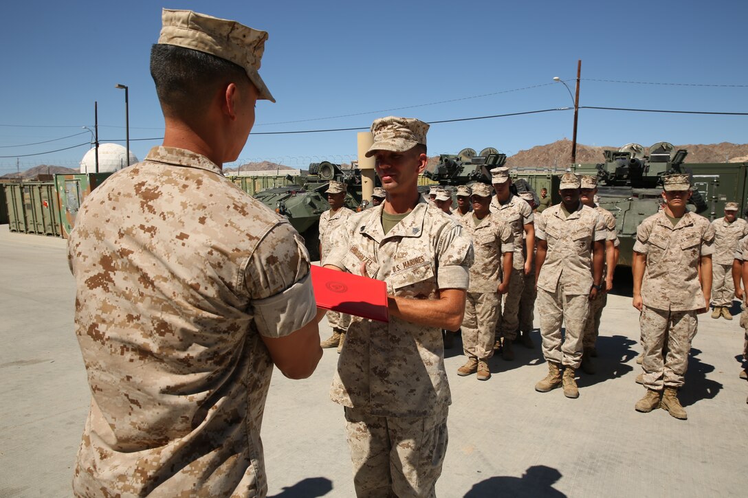 Capt. Kelvin Chew, communications officer, S-6, 3rd Light Armored Reconnaissance Battalion, hands Sgt. Arthur E. Krenzel III, field radio operator, 3rd LAR, his promotion warrant during his meritorious promotion ceremony at the Communications Building of 3rd LAR, Aug. 15, 2014.


