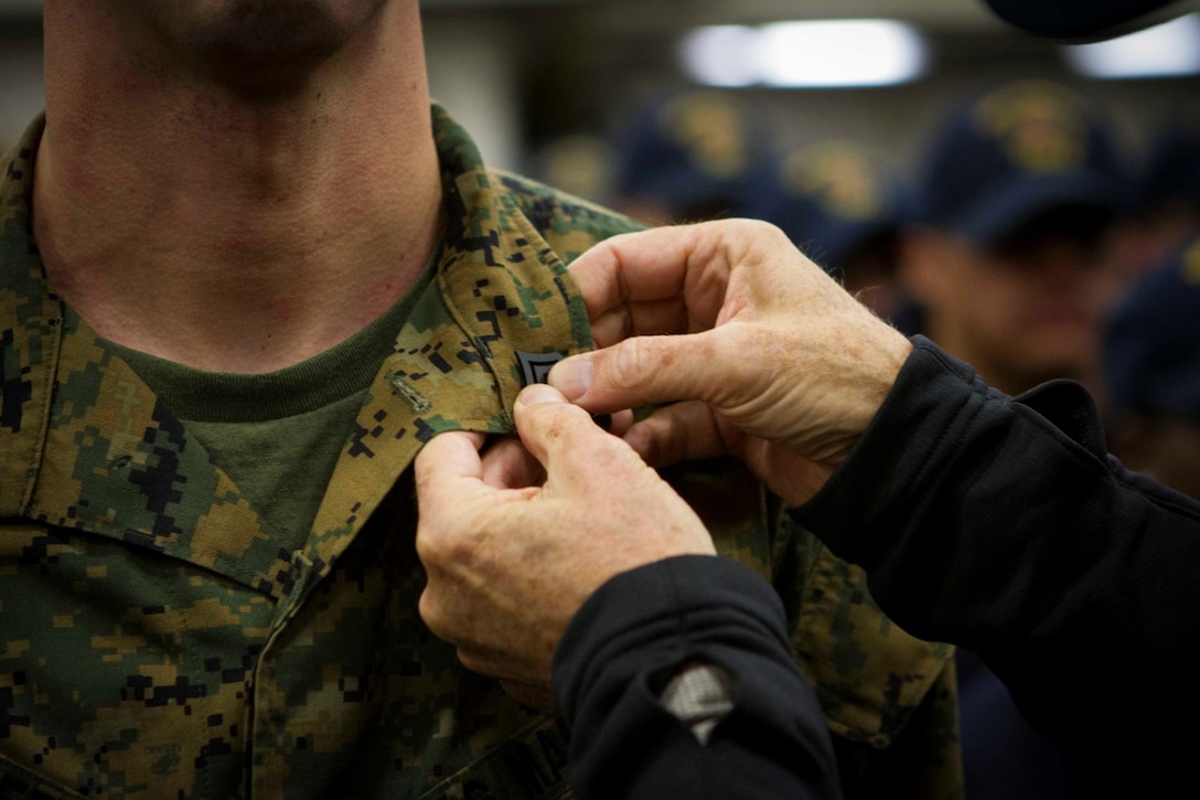 Secretary of the Navy Ray Mabus promotes Sgt. Louis Marrero, a Marine with Marine Operational Test and Evaluation Squadron 22, during a reenlistment and promotion ceremony held aboard the future amphibious assault ship USS America (LHA 6), Aug. 19, 2014. The reenlistment and promotions were held prior to an all hands meeting where Mabus addressed the Marines and Sailors with America and SPMAGTF-South. Mabus also toured the ship, had dinner with Marines and Sailors in the mess deck and attended an ice cream social. Visits like this remind the Marines and Sailors with America and the SPMAGTF of the significance of the work they are doing. SPMAGTF-South is embarked aboard America in support of her maiden transit, “America Visits the Americas.” Through partner-nation activities, theater security events and key leader engagements, the transit aims to demonstrate the flexibility, utility and unparalleled expeditionary capability the Navy-Marine Corps team provides our nation and partners. (U.S. Marine Corps Photo by Cpl. Donald Holbert/ Released)
