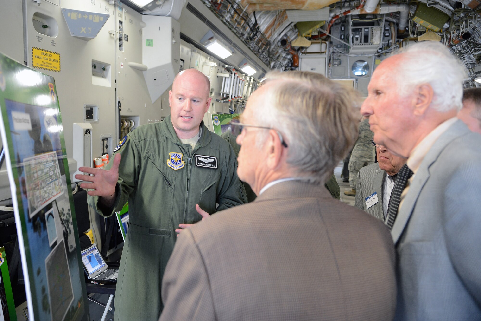 Capt. Steven Hawkins, 8th Airlift Squadron pilot, briefs members of the Defense Orientation Conference Association on the capabilities of the C-17 Globemaster III to perform precision airdrop, during a base visit Aug. 20, 2014, at Joint Base Lewis-McChord, Wash. DOCA schedules five visits per year, three of which are to military installations within the United States and two visits outside of the country. (U.S. Air Force photo/Airman 1st Class Jacob Jimenez)