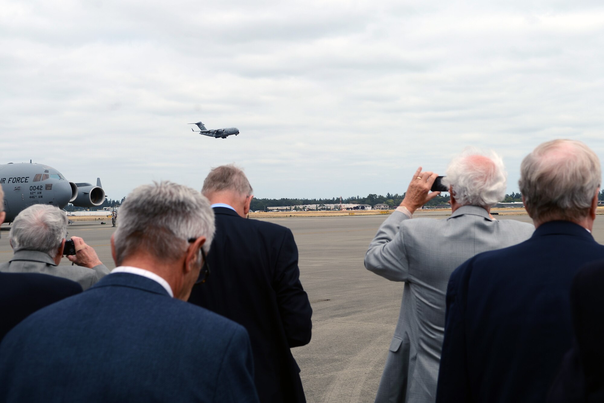 Members of the Defense Orientation Conference Association watch a C-17 Globemaster III perform a touch-and-go during a base tour Aug. 20, 2014, at Joint Base Lewis-McChord, Wash. DOCA was formed in 1952 as a non-profit, non-partisan organization by alumni of the Secretary of Defense Orientation Program with the goal to educate members on issues and challenges of national security.(U.S. Air Force photo/Airman 1st Class Jacob Jimenez)