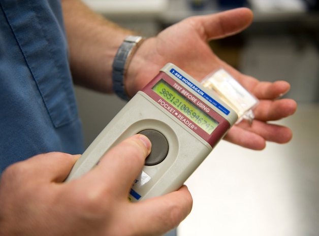 Dr. Michael Simpson, a Department of Army Civilian Veterinary medical officer, scans a new microchip to receive its embedded code at the Nellis Veterinary Treatment Facility at Nellis Air Force Base, Nev., Aug. 20, 2014. If a microchipped pet is lost, the code retrieved from the database helps reunite them with their families. (U.S. Air Force photo by Airman 1st Class Mikaley Towle)