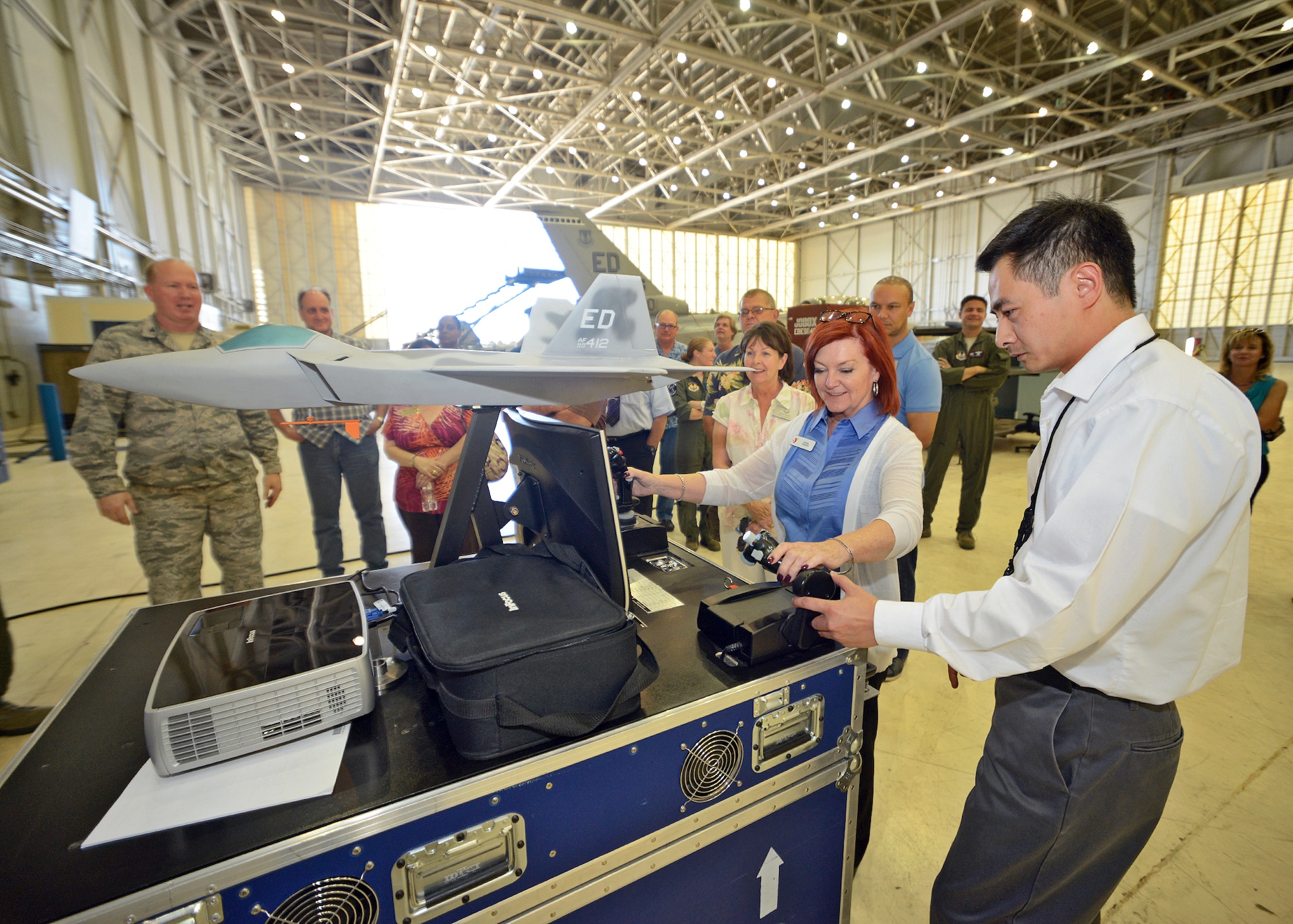 Donna Termeer, honorary commander for the 412th Test Management Division, operates the flight controls of an F-22 simulator that was set up at Hangar 1600 during a tour for the 412th Test Wing honorary commanders August 15. (U.S. Air Force photo by Jet Fabara)