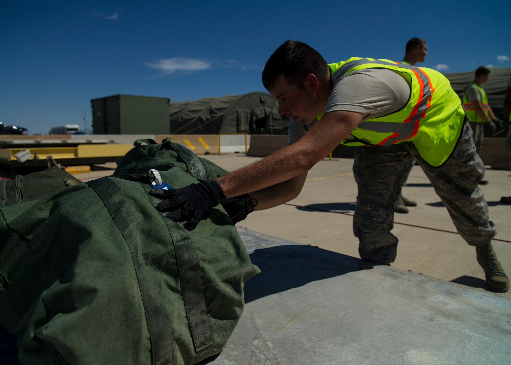 A Member of Team Holloman loads bags during a three-day deployment exercise at Holloman Air Force Base, N.M., Aug. 19. The exercise was a part of the Air Force’s Commanders Inspection Program. The program is designed to test a unit’s ability to accomplish the mission with little warning, and provides feedback on areas of excellence or areas that need improvement. The program specifically focuses on the bases ability to rapidly deploy combat-ready Airmen and equipment world-wide. (U.S. Air Force photo by Senior Airman Leah Ferrante/ Released)