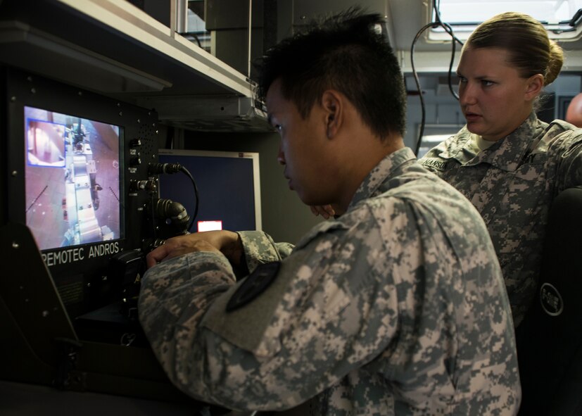 U.S. Army Spc. Steven Lovan and Spc. Leah Hanson, 75th Ordnance Disposal Company, 79th Ordnance Disposal Battalion, 71st Ordnance Group Explosive Ordnance Disposal team members, work together to make critical decisions during a training scenario Aug. 12, 2014, at Dyess Air Force Base, Texas. The 75th Ordnance Disposal Company Soldiers trained using Dyess’ F6A robots during a simulated urban scenario. After improvised suspicious packages were placed throughout an empty dorm building at Dyess AFB, teams would navigate the building, negotiate different methods of removing them and carry out the removal process. (U.S. Air Force photo by Senior Airman Peter Thompson/Released)