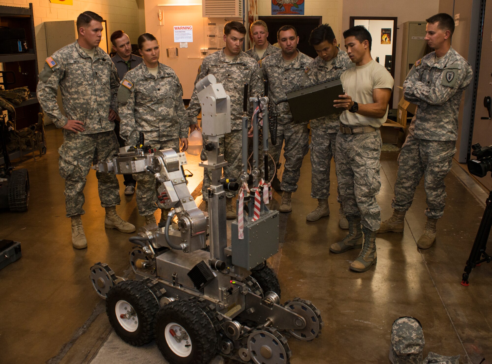 U.S. Air Force Airman 1st Class Sumitr Saetan, 7th Civil Engineer Squadron Explosive Ordnance Disposal technician, explains the functions and controls of an F6A EOD robotics system to U.S. Army EOD team members from the 75th Ordnance Disposal Company, 79th Ordnance Disposal Battalion, 71st Ordnance Group Aug. 11, 2014, at Dyess Air Force Base, Texas. During two days of training, Airmen from the 7th CES EOD flight worked alongside the Soldiers to get hands-on experience with equipment that wouldn’t be readily available to them at their home stations. (U.S. Air Force photo by Senior Airman Peter Thompson/Released)