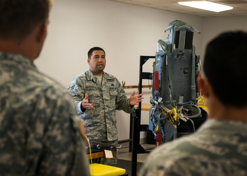 U.S. Air Force Staff Sgt. Eduardo Rojas, 7th Component Maintenance Squadron aircrew egress shift lead, explains the explosive components of an Aces 2 ejection seat found on a B-1B Lancer Aug. 11, 2014, at Dyess Air Force Base, Texas. During two days of training, Airmen from the 7th Civil Engineer Squadron Explosive Ordnance Disposal flight worked alongside U.S. Army Soldiers from the 75th Ordnance Disposal Company, 79th Ordnance Disposal Battalion, 71st Ordnance Group, to get hands-on experience with explosive hazards present on the B-1B Lancer and C-130J. Deployed EOD teams may be responsible for rendering explosive components of aircraft safe after emergencies or ejections. (U.S. Air Force photo by Senior Airman Peter Thompson/Released)