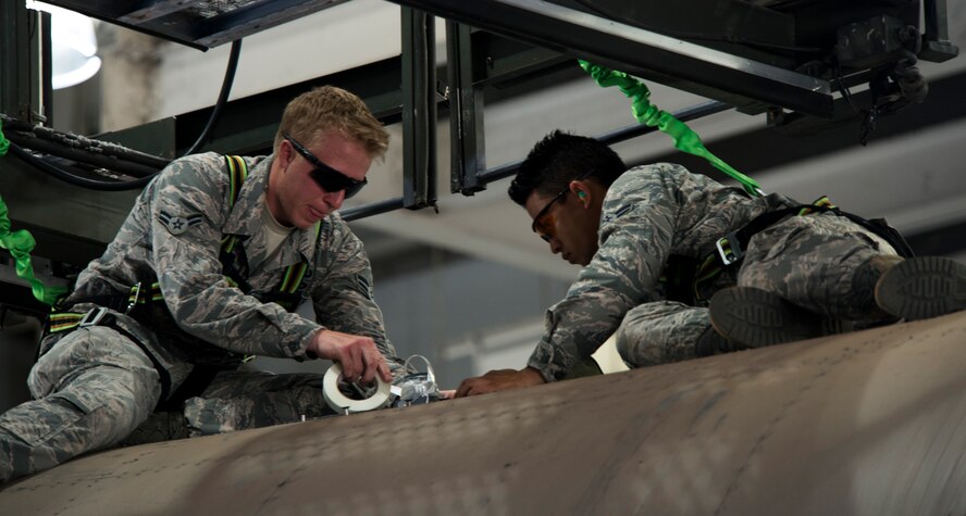 U.S. Air Force Airman 1st Class Luke Bryant and Airman 1st Class Sumitr Saetan, both 7th Civil Engineer Squadron Explosive Ordnance Disposal technicians, work together to secure a hung flare Aug. 11, 2014, at Dyess Air Force Base, Texas. EOD flight not only supports B-1B Lancer and C-130J aircraft stationed at Dyess, but supports other parts of the base and local areas. (U.S. Air Force photo by Senior Airman Peter Thompson/Released)