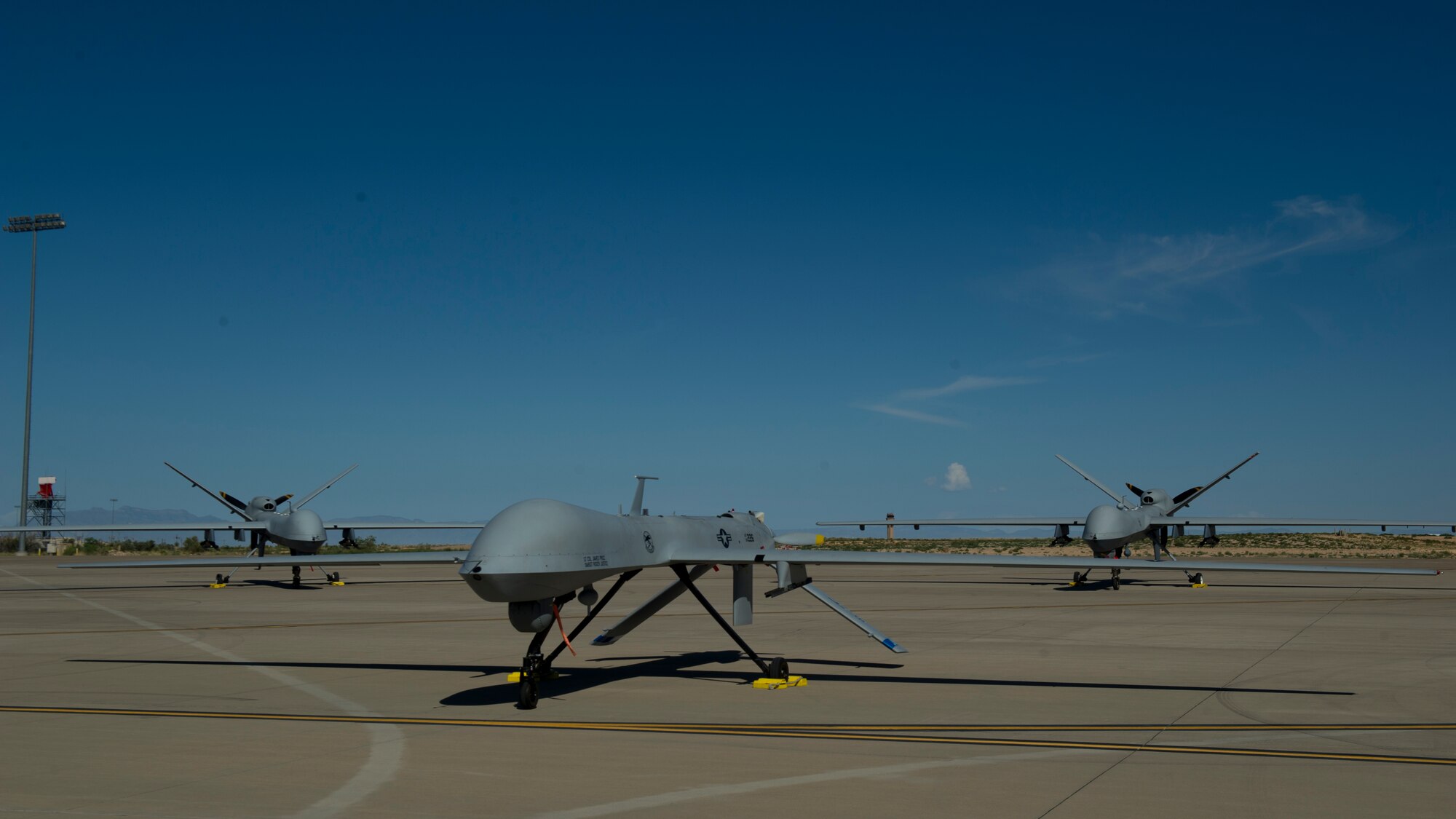 An MQ-1 Predator and MQ-9 Reaper sit on the flight line of Holloman Air Force Base, N.M., Aug. 19, prior to maintenance that will keep them flying and training the next generation of Air Force pilots and sensor operators. The MQ-1 Predator and MQ-9 Reaper both specialize in intelligence, surveillance and reconnaissance. Training for both aircraft is currently centralized at Holloman Air Force Base, N.M.  The MQ-1's primary mission is interdiction and conducting armed reconnaissance against critical, perishable targets. The MQ-9's primary mission is as a persistent hunter-killer against emerging targets to achieve joint force commander objectives.   (U.S. Air Force photo by Airman 1st Class Aaron Montoya/Released)