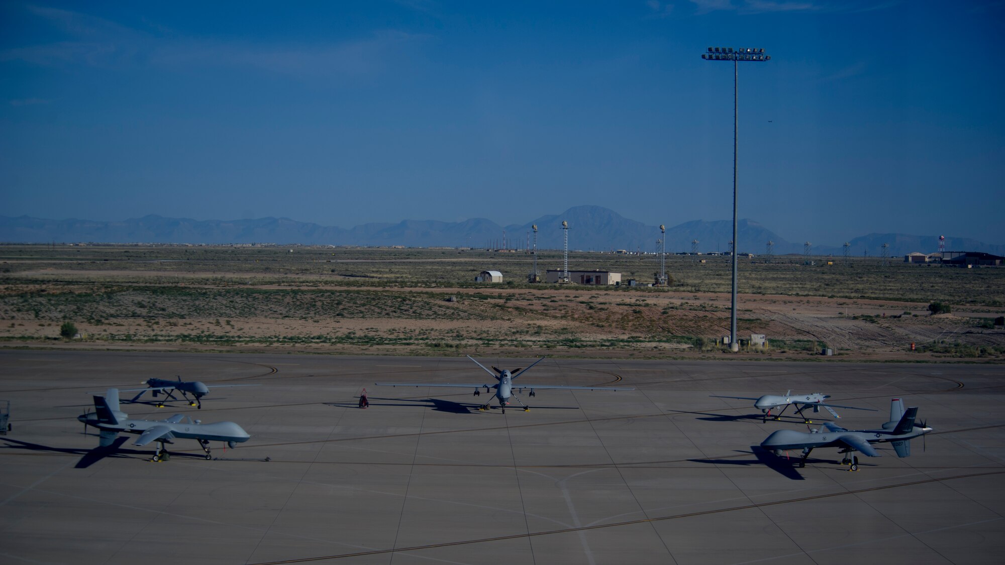 An MQ-1 Predator and MQ-9 Reaper sit on the flight line of Holloman Air Force Base, N.M., Aug. 19, prior to maintenance that will keep them flying and training the next generation of Air Force pilots and sensor operators. The MQ-1 Predator and MQ-9 Reaper both specialize in intelligence, surveillance and reconnaissance. Training for both aircraft is currently centralized at Holloman Air Force Base, N.M.  The MQ-1's primary mission is interdiction and conducting armed reconnaissance against critical, perishable targets. The MQ-9's primary mission is as a persistent hunter-killer against emerging targets to achieve joint force commander objectives.   (U.S. Air Force photo by Airman 1st Class Aaron Montoya/Released)