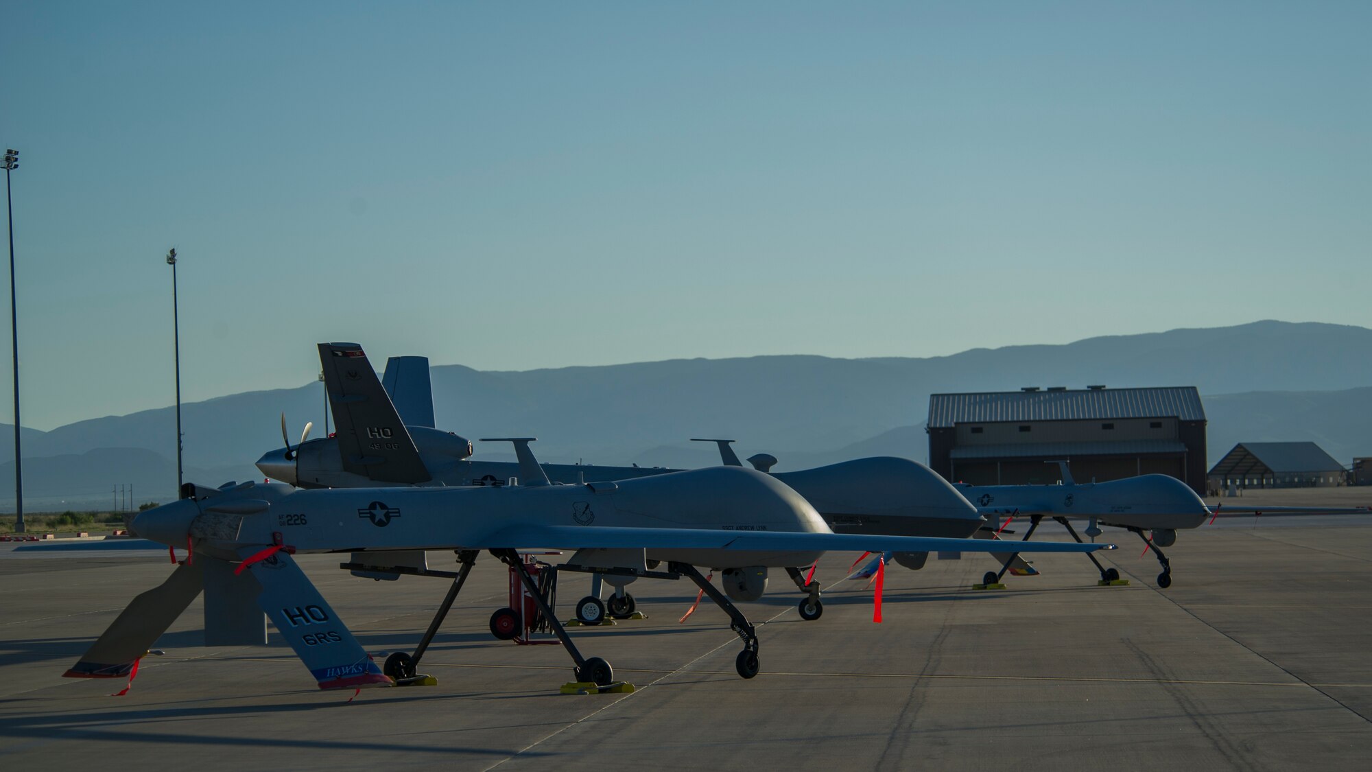 An MQ-1 Predator and MQ-9 Reaper sit on the flight line of Holloman Air Force Base, N.M., Aug. 19, prior to maintenance that will keep them flying and training the next generation of Air Force pilots and sensor operators. The MQ-1 Predator and MQ-9 Reaper both specialize in intelligence, surveillance and reconnaissance. Training for both aircraft is currently centralized at Holloman Air Force Base, N.M.  The MQ-1's primary mission is interdiction and conducting armed reconnaissance against critical, perishable targets. The MQ-9's primary mission is as a persistent hunter-killer against emerging targets to achieve joint force commander objectives.   (U.S. Air Force photo by Airman 1st Class Aaron Montoya/Released)