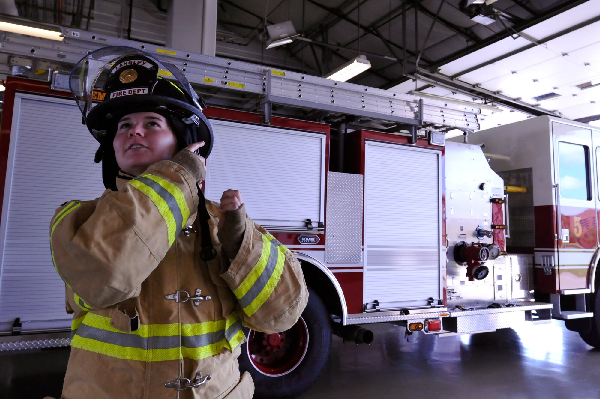 U.S. Air Force Airman 1st Class Jessica Braisted, 633rd Civil Engineer Squadron firefighter, dons her helmet at Langley Air Force Base, Va., Aug. 20, 2014. Braisted is one of two women currently working at the fire department. As Women’s Equality Day approaches, Braisted said she wants to continue to be treated equally as a firefighter and not solely as a female. (U.S. Air Force photo by Airman 1st Class Breonna Veal/Released)  