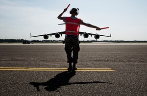 Airman 1st Class Dillon Varner, 437th Aircraft Maintenance Squadron crew chief,
marshals a C-17 Globemaster III aircraft to the taxi way on Aug. 19, 2014, at Joint
Base Charleston, S.C. The flight crew performed air-drop training at North Auxiliary
Field. (U.S. Air Force photo/Senior Airman Dennis Sloan)
