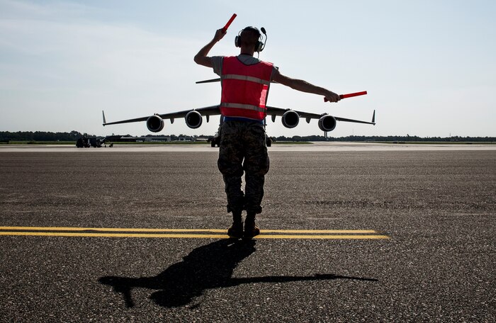 Airman 1st Class Dillon Varner, 437th Aircraft Maintenance Squadron crew chief,
marshals a C-17 Globemaster III aircraft to the taxi way on Aug. 19, 2014, at Joint
Base Charleston, S.C. The flight crew performed air-drop training at North Auxiliary
Field. (U.S. Air Force photo/Senior Airman Dennis Sloan)
