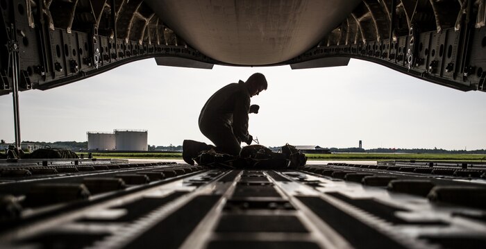 Senior Airman Zachary Buzzard, 14th Airlift Squadron loadmaster, secures a parachute for a pallet on a C-17 Globemaster III Aug. 19, 2014, at Joint Base Charleston, S.C. Buzzard performed air-drop training over North Auxiliary Field while another loadmaster observed. (U.S. Air Force photo/Senior Airman Dennis
Sloan)
