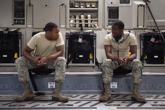 Senior Airman Edward Tucker and Airman 1st Class Jordan Mitchell, 437th Aircraft Maintenance Squadron crew chiefs, talk to each other during downtime while performing aircraft maintenance, Aug. 19, 2014, at Joint Base Charleston, S.C. Flightline Airmen maintain the aircraft that keep the mission running. (U.S. Air Force photo/Senior Airman George Goslin)