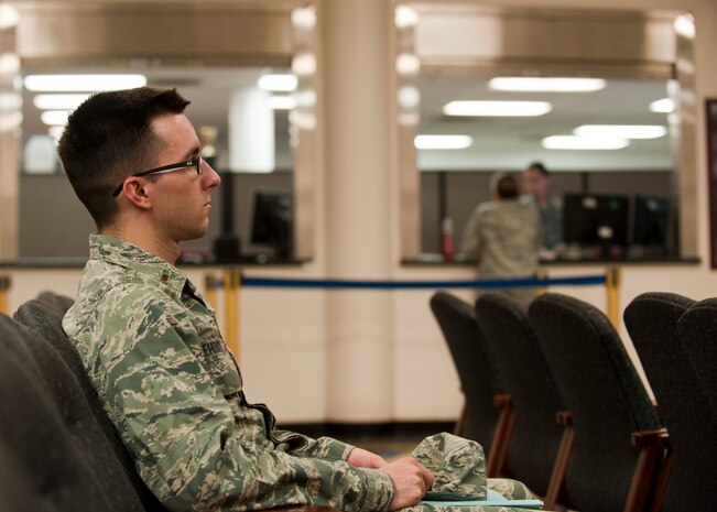 2nd Lt. Chase Lehocky, 99th Contracting Squadron contracting officer, waits to be helped at the finance office at Nellis Air Force Base Nev., Aug. 18, 2014. Customer service technicians from the 99th Comptroller Squadron handle all permanent change of station payments, post-deployment financial actions, government travel card inquiries and travel voucher payments. (U.S. Air Force photo by Airman 1st Class Thomas Spangler)