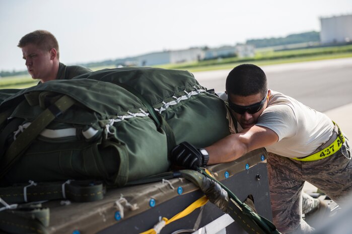 Senior Airman Custodio Sanchez, 437th Aerial Port Squadron air transportation technician, pushes cargo onto a C-17 Globemaster III, Aug. 19, 2014, at Joint Base Charleston, S.C. The cargo was dropped during a training mission over North Auxiliary Airfield. (U.S. Air Force photo/Senior Airman George Goslin)