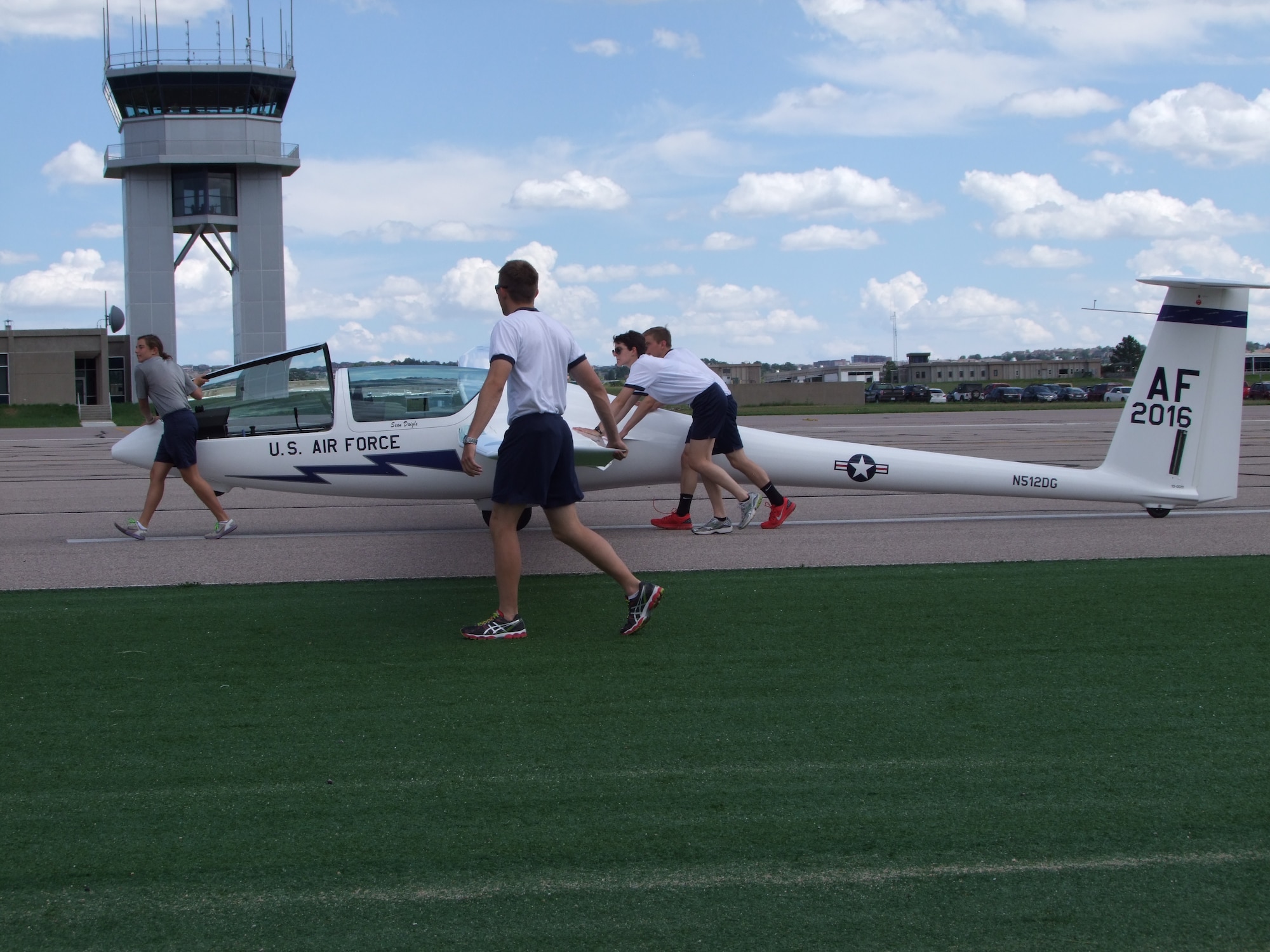 Upgraders and instructor pilots push a TG-16A glider down the runway to be hooked to a tow plane Aug. 15 at the airfield. (U.S. Air Force photo/Amber Baillie)