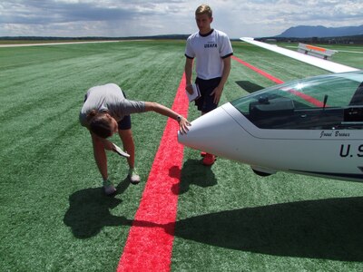 Cadet 2nd Class Brianna Pauser, Airmanship 461 instructor pilot, and upgrader, Cadet 3rd Class Alex Keller, conduct a pre-flight inspection of a TG-16A glider before take-off Aug. 15. (U.S. Air Force photo/Amber Baillie)