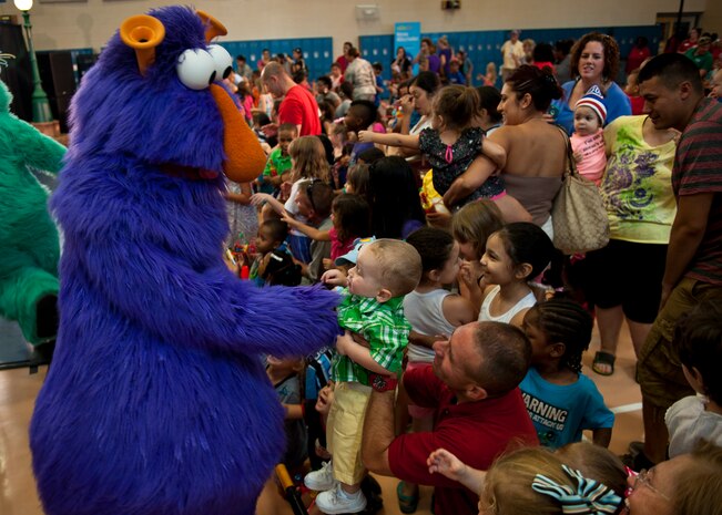 The Purple Honker, a Sesame Street character, interacts with service members and their families during a Sesame Street/USO Experience for Military Families show at the Youth Center, Nellis Air Force Base, Nev., Aug. 15, 2014. The show emphasized the importance of adjusting to change and the power of friendship. (U.S. Air Force photo by Airman 1st Class Mikaley Towle)