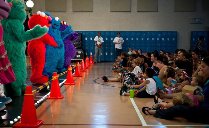 Members of the Sesame Street/USO Experience for Military Families perform for Airmen and their families at the Youth Center, Nellis Air Force Base, Nev., Aug. 15, 2014. The performance helped military children understand they are not alone and provided outreach materials to military families who attended. (U.S. Air Force photo by Airman 1st Class Mikaley Towle)