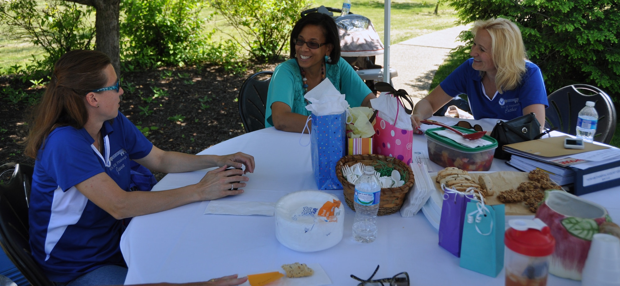 Jana Johnson and Kathy Peters (both in purple shirts) discuss volunteering opportunities with the Key Spouse Program with Cathy Sigmund, June 7, 2014, at Pittsburgh International Airport Air Reserve Station. (U.S. Air Force photo by Senior Airman Joseph E. Bridge)