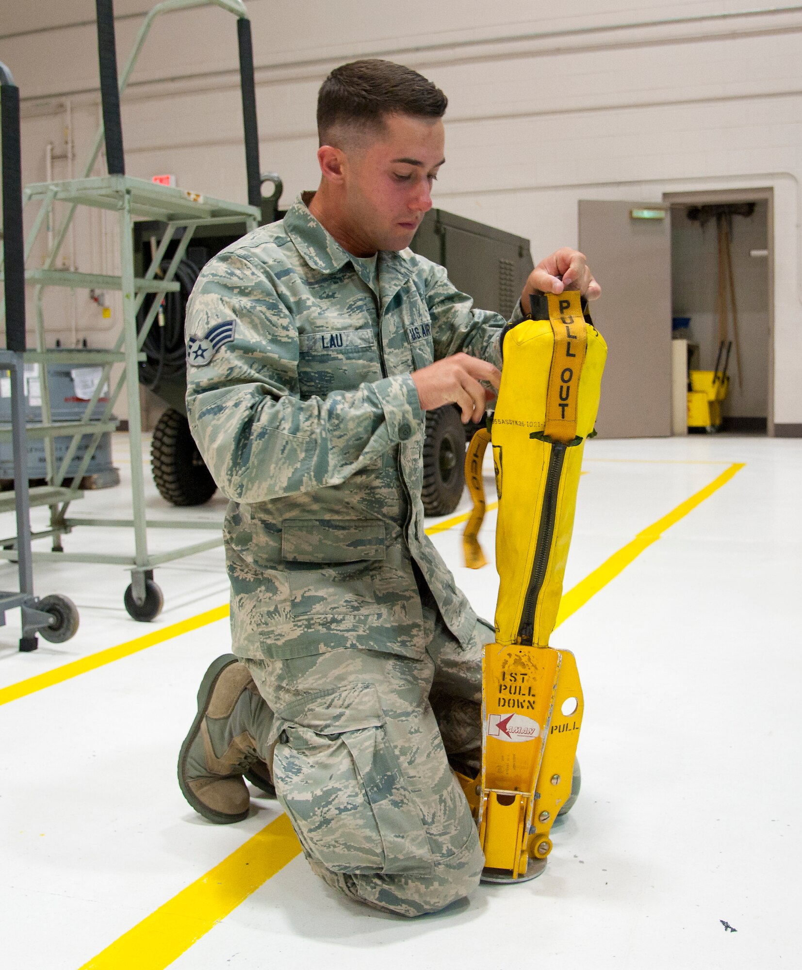 Senior Airman Isaac Lau, 341st Security Forces Group Tactical Response Force member, familiarizes himself with a personnel extraction device, known as a “Penetrator,” in preparation to compete in the Global Strike Challenge.  The Penetrator connects to a 250-foot-long hoist cable and allows personnel to be safely inserted or extracted from terrain that is too rough for a helicopter to land in. (U.S. Air Force photo/Airman 1st Class Collin Schmidt)