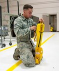Senior Airman Isaac Lau, 341st Security Forces Group Tactical Response Force member, familiarizes himself with a personnel extraction device, known as a “Penetrator,” in preparation to compete in the Global Strike Challenge.  The Penetrator connects to a 250-foot-long hoist cable and allows personnel to be safely inserted or extracted from terrain that is too rough for a helicopter to land in. (U.S. Air Force photo/Airman 1st Class Collin Schmidt)