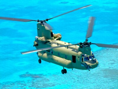 A new CH-47F Chinook helicopter flies off the coast of Belize June 21, 2014, on the way to its new home with the 1-228th Aviation Regiment at Soto Cano Air Base, Honduras.  The 1-228th Aviation Regiment transitioned to the new air frame from the CH-47D after being the last active duty unit in the Army to fly the historic behemoths, which began their service during the 1960’s.   (Courtesy Photo)