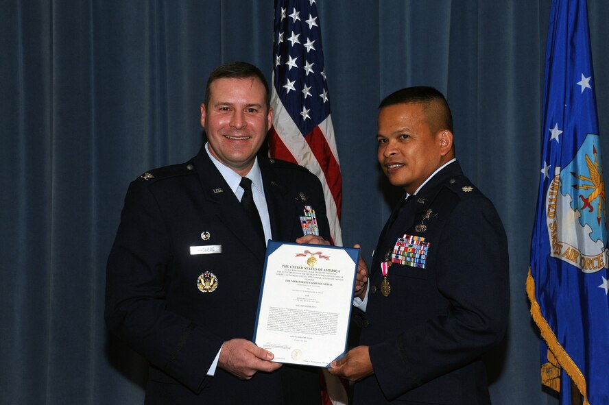 Col. Chad Raduege, left, 690th Cyberspace Operations Group commander, awards the Meritorious Service Medal to departing commander Lt. Col. Eric Trias, 690th Network Support Squadron commander, at Maxwell-Gunter Annex, Ala., Aug. 15, 2014.Trias is going on to become the Chief of Enterprise Architecture at the Pentagon.( U.S Air force photo by Airman 1st Class Alexa Culbert)