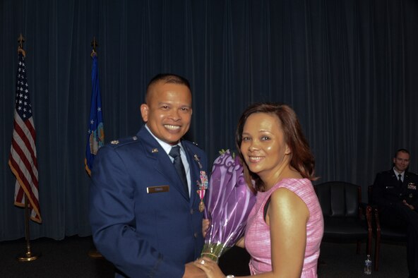 Lt. Col Eric Trias, 690th Network Support Squadron Detachment 2 commander, presents flowers to his wife during the 690th NSS change of command ceremony at Maxwell-Gunter Annex, Ala., Aug. 15, 2014. Trias relinquished his role as commander to Capt. Timothy Labinski, 26th Network Operations Squadron operations flight commander.( U.S Air Force photo by Airman 1st Class Alexa Culbert)