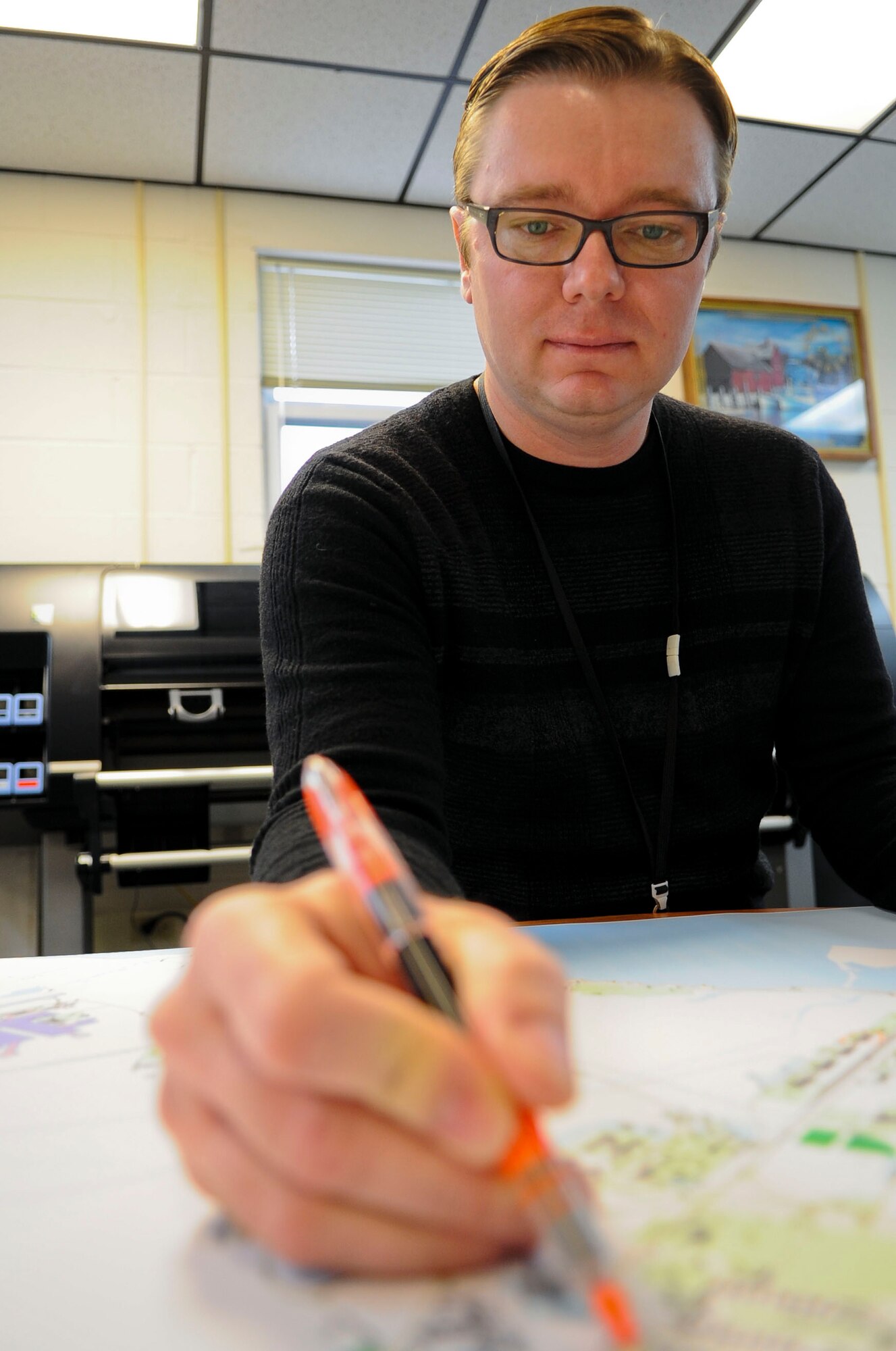 Chris Beemer, 733rd Civil Engineer Division cartographer, marks a map at Fort Eustis, Va., Dec. 9, 2013. The 733rd CED coordinates with project managers on upcoming construction projects to keep installation maps up-to-date. Beemer hails from Abilene, Kan. (U.S. Air Force photo by Airman 1st Class Austin Harvill/Released)