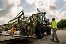 U.S. Air Force Senior Airman Gregory McMillan, 23d Logistics Readiness Squadron, loads palate supports onto a forklift during a cargo deployment function exercise at Moody Air Force Base, Ga., Aug. 19, 2014. The exercise tested the 23d Wing’s ability to deploy equipment in addition to Airmen. (U.S. Air Force photo by Airman 1st Class Ryan Callaghan/Released)