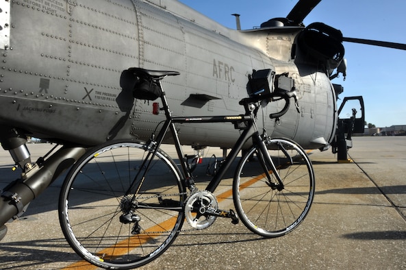 A bike leans against an HH-60G Pave Hawk helicopter from the 920th Rescue Squadron, Patrick Air Force Base, Fla., August 19, 2014. Members from the 920th Maintenance Squadron are part of a cycling club and plan to participate in the Rocketman Florida Triathlon, October 12, 1014. (U.S. Air Force photo/ Tech. Sgt. Katie Spencer) 