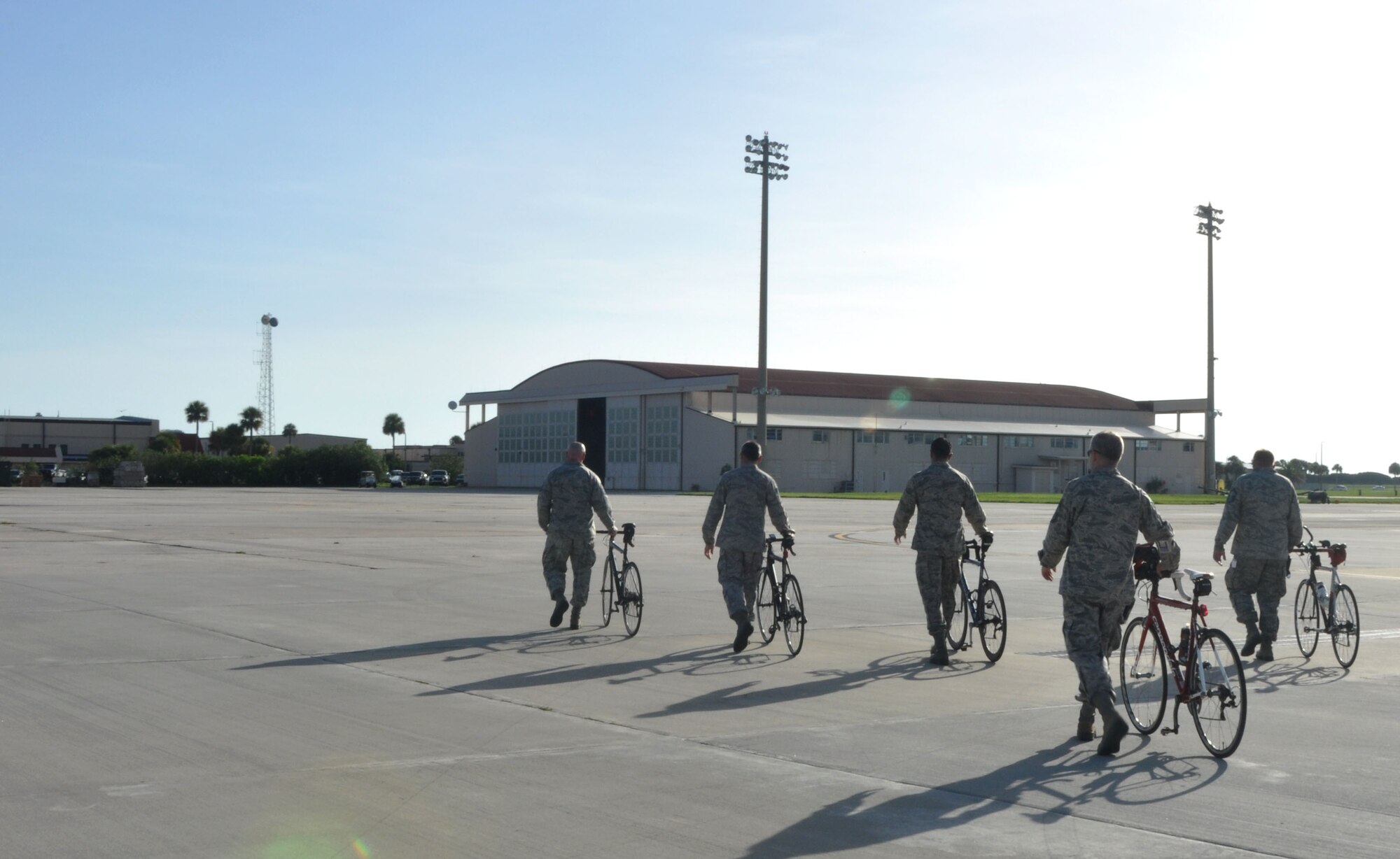Members from the 920th Maintenance Squadron walk their bikes on the flightline, Patrick Air Force Base, Fla., August 19, 2014. The members are part of a cycling club and plan to participate in the Rocketman Florida Triathlon, October 12, 1014. (U.S. Air Force photo/ Tech. Sgt. Katie Spencer) 