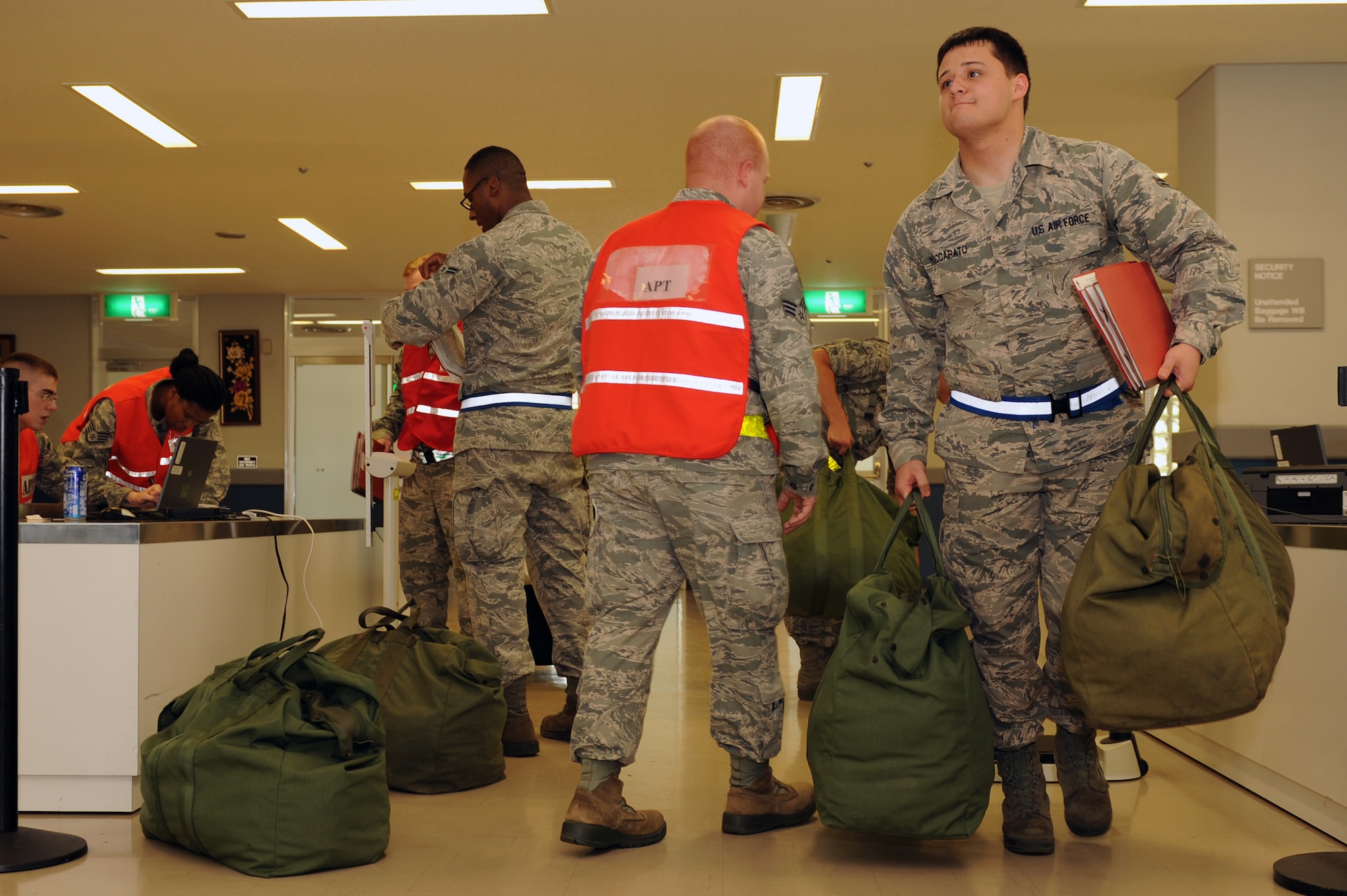U.S. Air Force Airman 1st Class Zachry Naccarato, 718th Aircraft Maintenance Squadron crew chief, takes his mobility bags and folder from one station of a personnel deployment function line to the next on Kadena Air Base, Japan, Aug. 19, 2014. PDF lines ensure Airmen stay deployment ready by making sure they have the necessary paperwork and equipment. (U.S. Air Force photo by Airman 1st Class Zade C. Vadnais/Released)