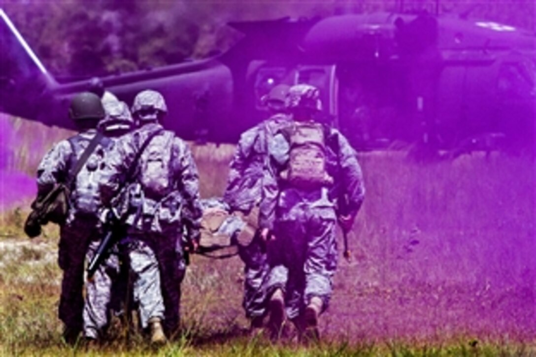 Army Reserve soldiers carry a simulated casualty to an awaiting UH-60M helicopter during a medical evacuation exercise on Camp Blanding, Fla., Aug. 19, 2014. The Army Reserve soldiers are assigned to the 724th Military Police Battalion on Fort Lauderdale, Fla. The soldiers focused on movement and evacuation techniques as they trained with the Guard's C Company, 1st Battalion, 111th Aviation Regiment.