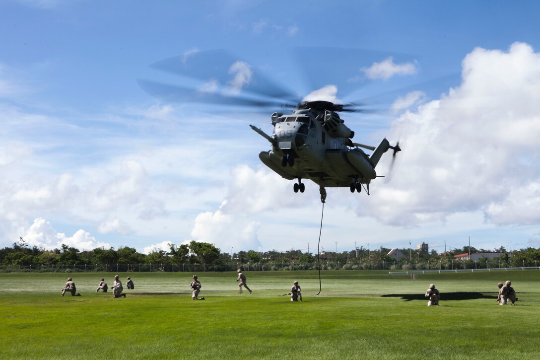 A CH-53E with Marine Medium Tiltrotor Squadron 262, 31st Marine Expeditionary Unit, hovers during insertion and extraction drills as Marines from the 5th Air Naval Gunfire Liaison Company post security at the parade deck at Camp Hansen, Okinawa, Japan, Aug. 20, 2014. The Marines practiced the fast rope skill for missions such as a visit, board, search, and seizure operations, in which they would descend from the aircraft onto the deck of a ship. The 31st MEU is the force of choice in the Asia-Pacific region and the only continuously forward-deployed MEU. 