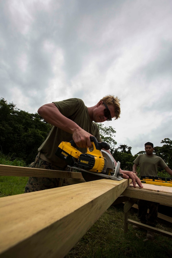 U.S. Marine Lance Cpl. Adam Gilliam, a combat engineer with 8th Engineer Support Battalion (ESB) cuts  wood for a South West Asia (SWA) hut. The SWA hut is being built as a multi-purpose classroom for the Brigada De Infantería de Marina (BIM) at the BIM base, Puerto Barrios, Guatemala, Aug. 12, 2014. The Combat Engineers are part of Southern Partnership Station 14, a combined joint exercise focused on subject matter expert exchanges with partner nations and security forces as well as military to military engagements and community relations projects in Central America. (U.S. Marine Corps photo by Cpl. Nicholas T. Nohalty, 2D MARDIV Combat Camera/Released)