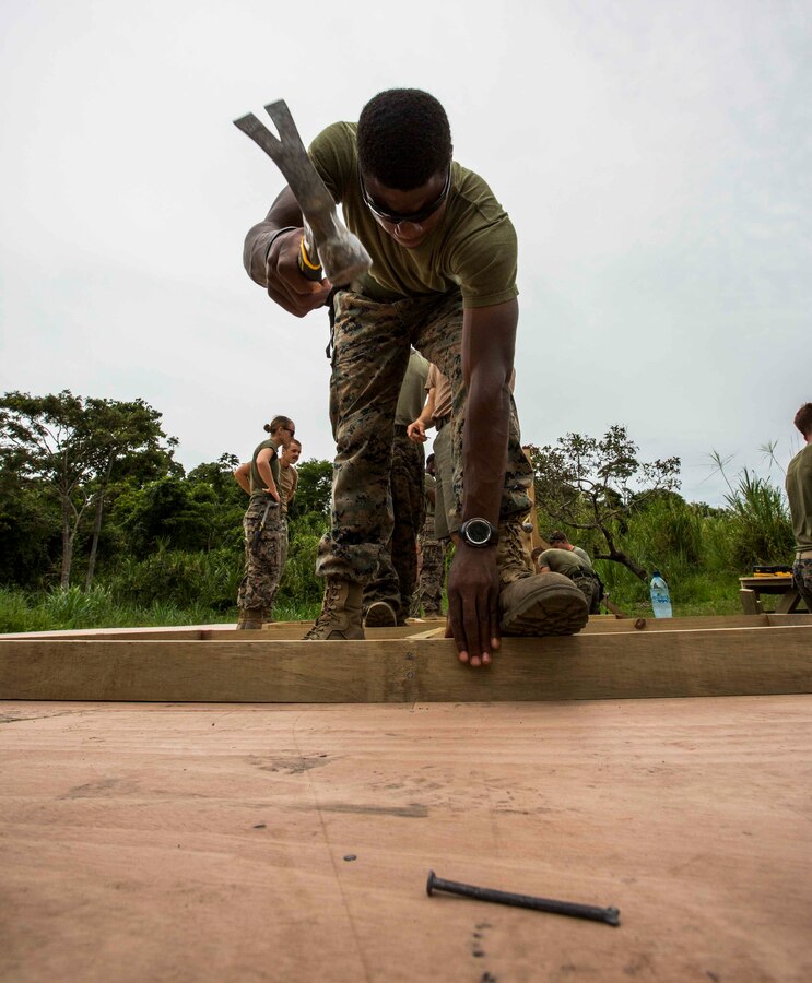 U.S. Marine Cpl. Michael Bostic, a combat engineer with 8th Engineer Support Battalion (ESB) hammers a nail in a platform for a South West Asia (SWA) hut. The SWA hut is being built as a multi-purpose classroom for the Brigada De Infantería de Marina (BIM) at the BIM base, Puerto Barrios, Guatemala, Aug. 12, 2014. The Combat Engineers are part of Southern Partnership Station 14, a combined joint exercise focused on subject matter expert exchanges with partner nations and security forces as well as military to military engagements and community relations projects in Central America. (U.S. Marine Corps photo by Cpl. Nicholas T. Nohalty, 2D MARDIV Combat Camera/Released)