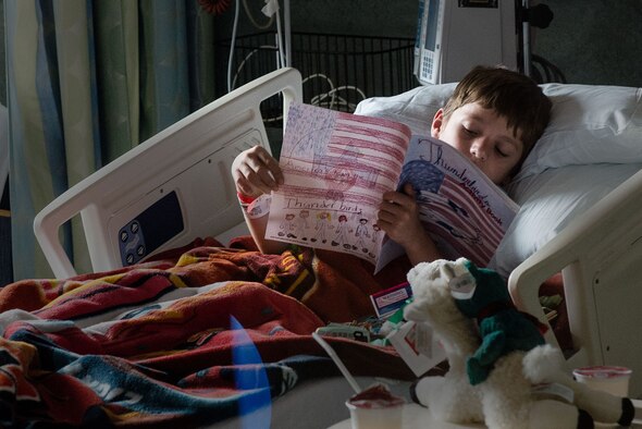A patient at the Golisano Children's Hospital looks through his Thunderbirds coloring book after being visited by U.S. Air Force Air Demonstration Squadron team members Aug. 15, 2014, during the Rochester International Air Show in Rochester, N.Y. (U.S. Air Force photo/Tech. Sgt. Manuel J. Martinez)
