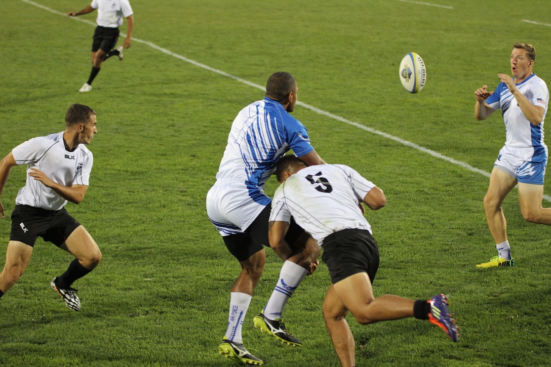 Air Force Capt. Eric Duechle (#1) from Chula Vista, Cala delivers a pass to teammate Staff Sgt. Thomas Heath in Air Force's 26-5 victory over Marine Corps at the 2014 Armed Forces Rugby 7’s Championship in Glendale, Colo. 15-17 August.
