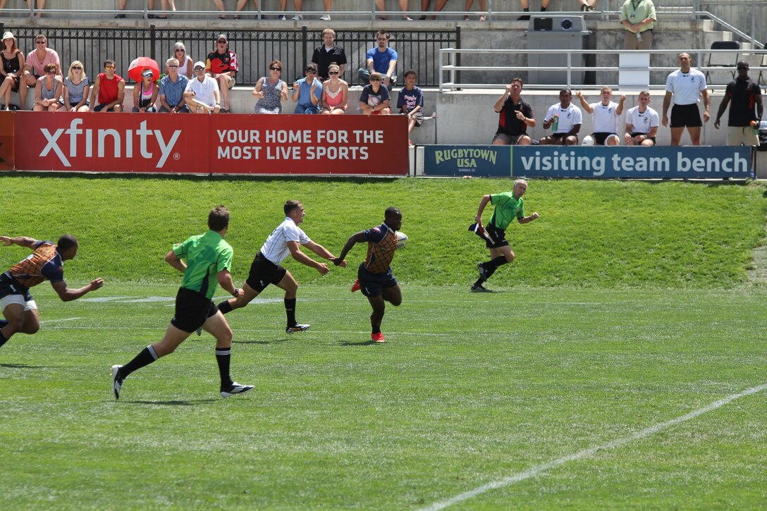 Seaman Apprentice Dejon Dawsey from NAS Sigonella breaks a tackle on his way to the try zone for a Navy score helping the Navy defeat the Marine Corps 26-14 at the 2014 Armed Forces Rugby 7’s Championship in Glendale, Colo. 15-17 August.