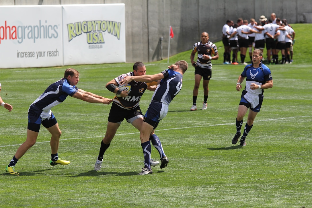 Army Capt. John Bryant from South Carolina Nation Guard jams Air Force Capt. Nathan Terrazone (#4) from Los Angeles AFB, Cala. at the 2014 Armed Forces Rugby 7’s Championship in Glendale, Colo. 15-17 August.
