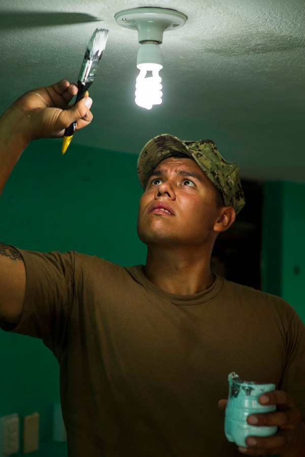 U.S. Navy Construction Electrician 2 Arthur Bernahl, a Seabee from Construction Battalion Maintenance Unit 202, paints the ceiling that was filled in with stucco. The Guatemalan Brigada de Infanteria de Marina (BIM) engineers along with their U.S. counterparts help renovate the Biblioteca Municipal Corporacion 74-78 as part of a humanitarian engineering project in Puerto Barrios, Guatemala, Aug. 14, 2014. The Marines and Sailors are helping to remodel buildings in support of Southern Partnership Station 2014, a combined joint exercise focused on subject matter expert exchanges with partner nations and security forces as well as military to military engagements and community relations projects in Central America. (U.S.  Marine Corps photo by Lance Cpl. Chloe Nelson, 2D MAR DIV Combat Camera/ Released)