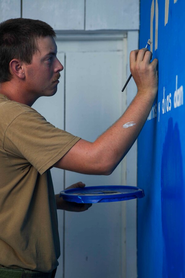 U.S. Navy Utilitiesman 2 Robert Arthur, a Seabee from Construction Battalion Maintenance Unit 202, paints a murual that he has designed for a local library in the Izabal District. The Guatemalan Brigada de Infanteria de Marina (BIM) engineers along with their U.S. counterparts help renovate the Biblioteca Municipal Corporacion 74-78 as part of a humanitarian engineering project in Puerto Barrios, Guatemala, Aug. 14, 2014. The Marines and Sailors are helping to remodel buildings in support of Southern Partnership Station 2014, a combined joint exercise focused on subject matter expert exchanges with partner nations and security forces as well as military to military engagements and community relations projects in Central America. (U.S.  Marine Corps photo by Lance Cpl. Chloe Nelson, 2D MAR DIV Combat Camera/ Released)